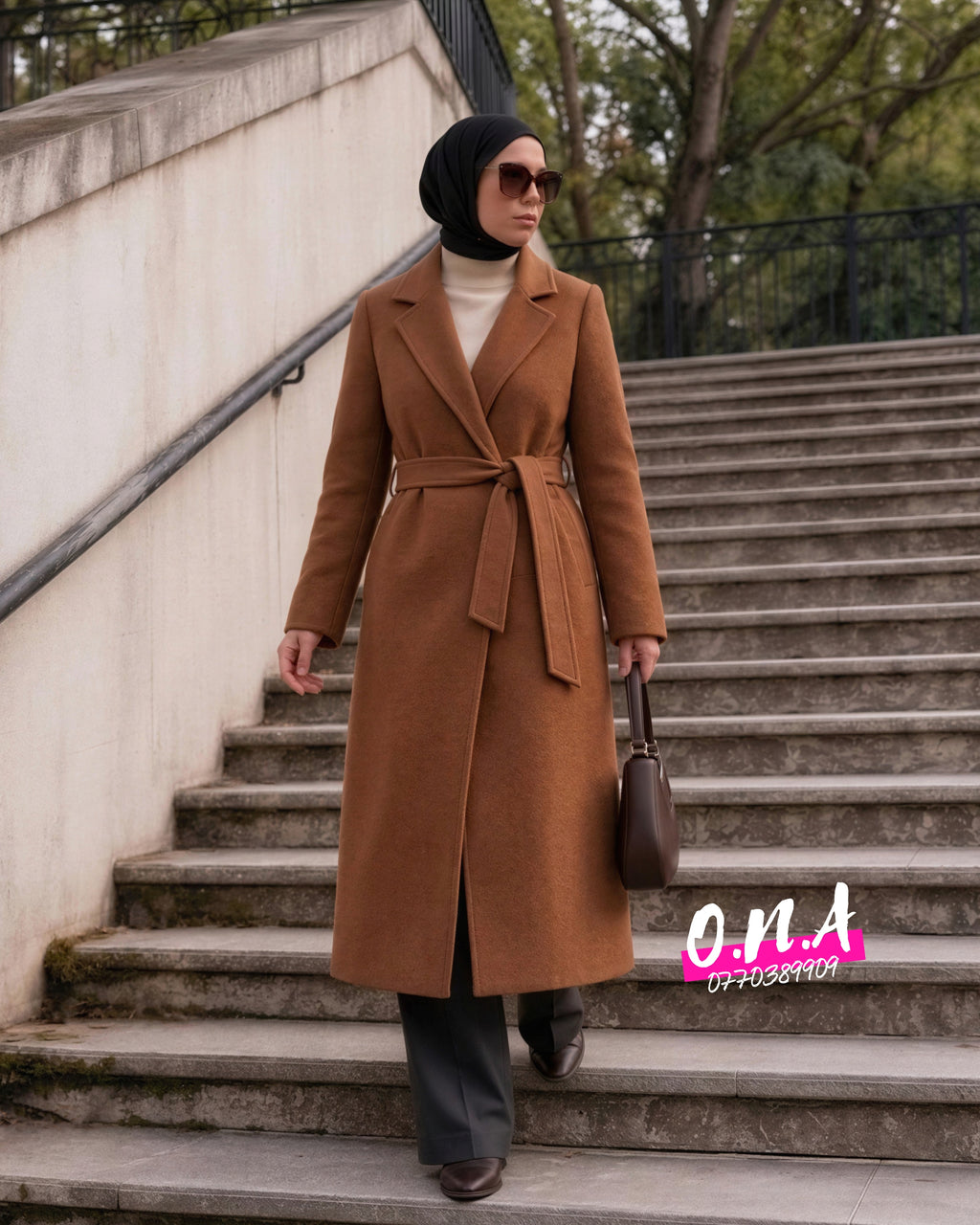 Manteau Héritage ONA marron cognac porté en extérieur, fermé et ceinturé